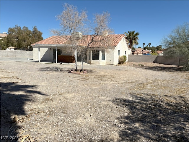 back of property featuring a tile roof, fence, and stucco siding