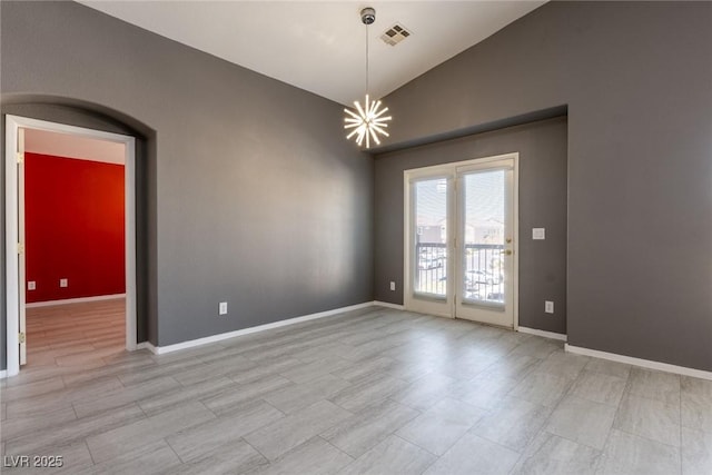 empty room with a notable chandelier, baseboards, vaulted ceiling, and visible vents