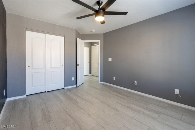 unfurnished bedroom with a closet, baseboards, and ceiling fan