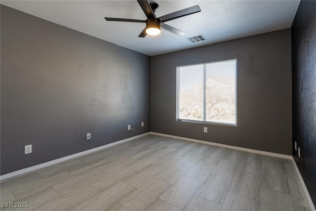 spare room with visible vents, baseboards, and ceiling fan