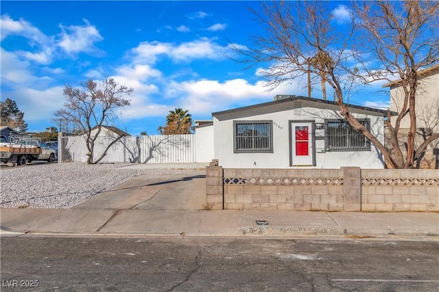 view of front of home featuring a fenced front yard, a gate, and stucco siding