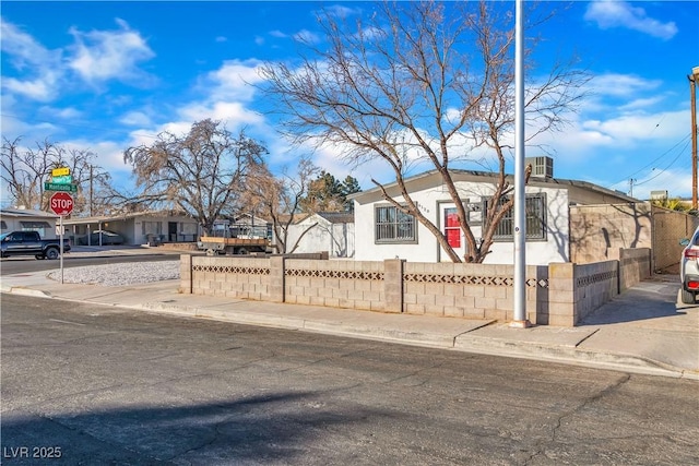 view of front of property with concrete driveway and a fenced front yard