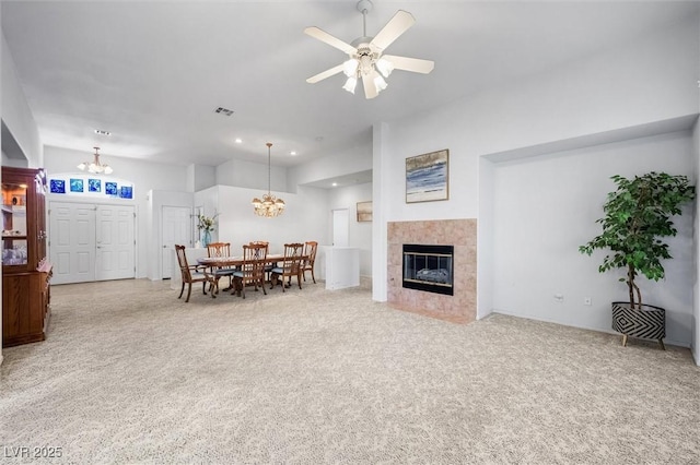 living room with visible vents, a tile fireplace, carpet, ceiling fan with notable chandelier, and recessed lighting