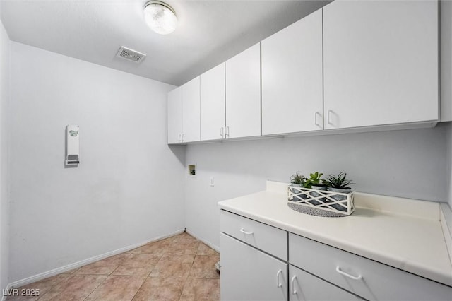 washroom featuring light tile patterned flooring, hookup for a washing machine, visible vents, baseboards, and cabinet space