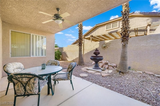 view of patio with a fenced backyard, a ceiling fan, and outdoor dining space