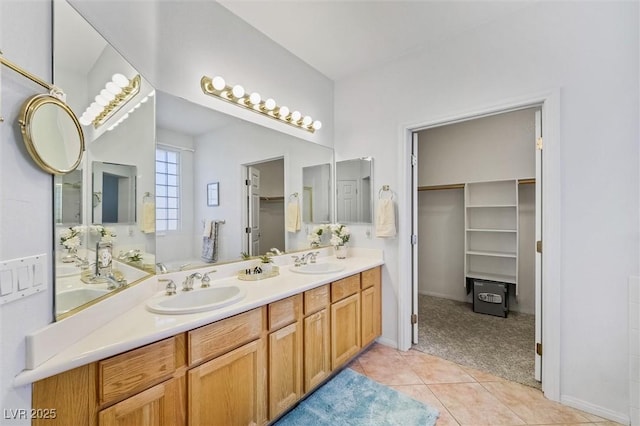 full bathroom with double vanity, a sink, a spacious closet, and tile patterned floors