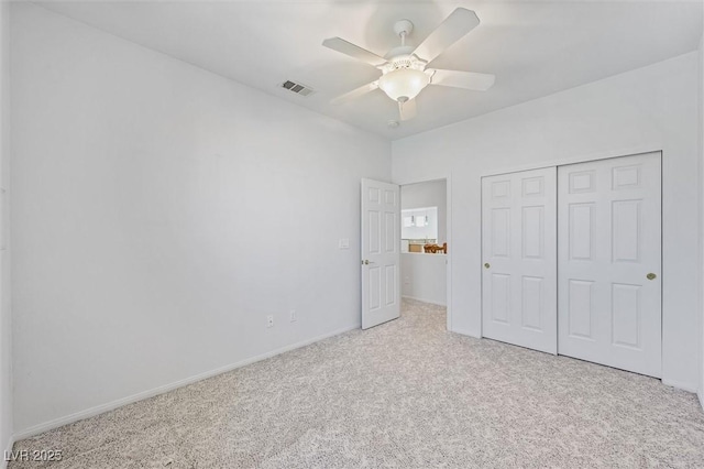 unfurnished bedroom with visible vents, baseboards, a ceiling fan, carpet, and a closet