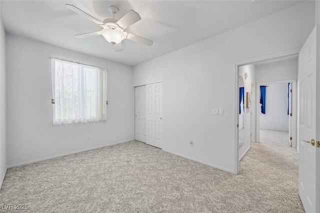 unfurnished bedroom with carpet floors, a ceiling fan, and a closet