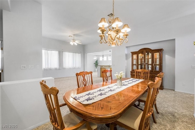 dining space featuring light colored carpet, visible vents, and ceiling fan with notable chandelier