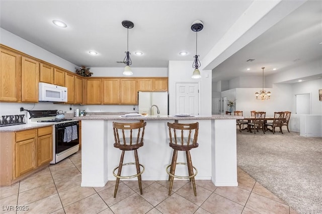 kitchen featuring a breakfast bar area, light colored carpet, white appliances, a center island with sink, and pendant lighting