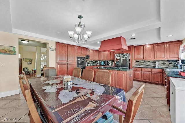 kitchen with backsplash, black appliances, light tile patterned floors, and a tray ceiling