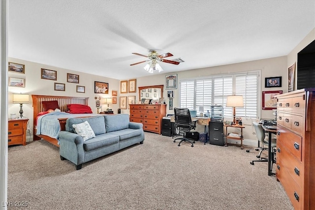 carpeted bedroom with ceiling fan, a textured ceiling, and baseboards