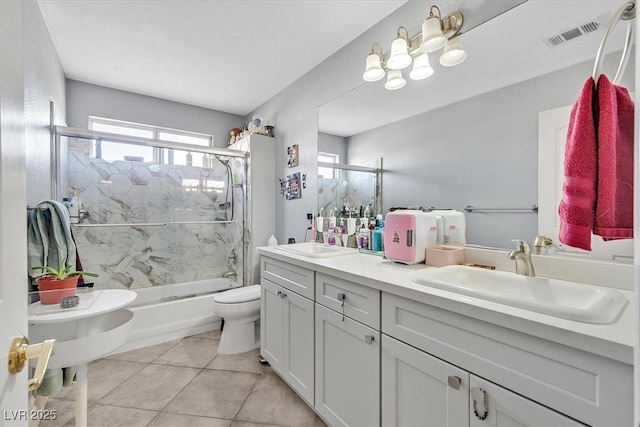 full bathroom featuring combined bath / shower with glass door, toilet, visible vents, and a sink