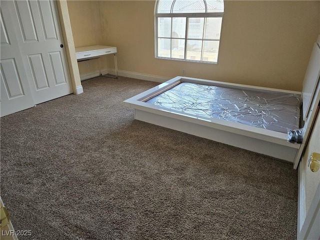 unfurnished bedroom with baseboards and carpet