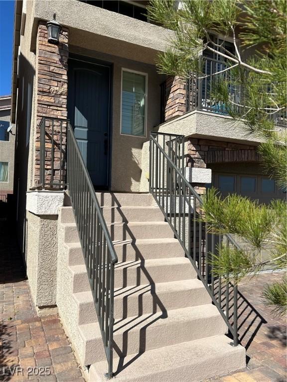 property entrance with stone siding and stucco siding