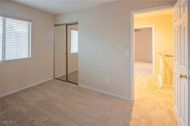 unfurnished bedroom featuring carpet floors, a closet, and baseboards