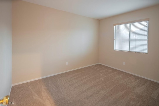 carpeted empty room featuring baseboards