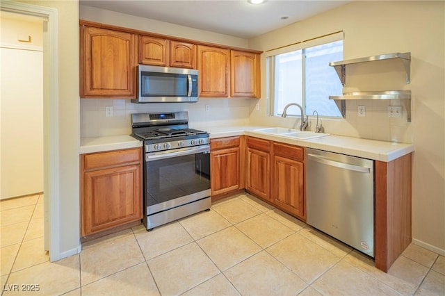 kitchen featuring appliances with stainless steel finishes, a sink, decorative backsplash, and light tile patterned floors