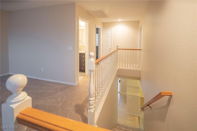 staircase with carpet floors, visible vents, and baseboards