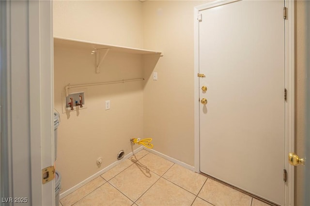 clothes washing area with light tile patterned floors, hookup for a washing machine, gas dryer hookup, laundry area, and baseboards