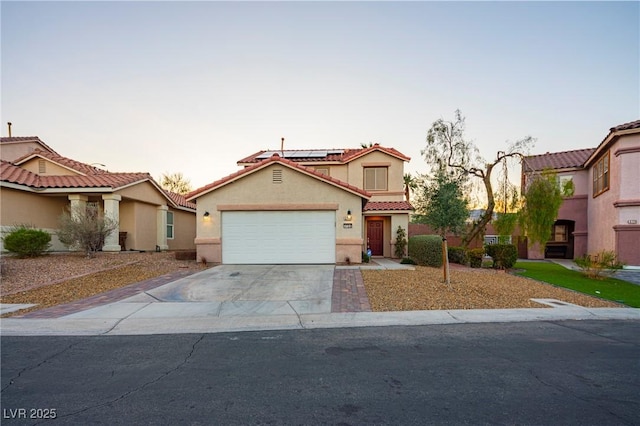 view of front facade with concrete driveway, roof mounted solar panels, an attached garage, and stucco siding