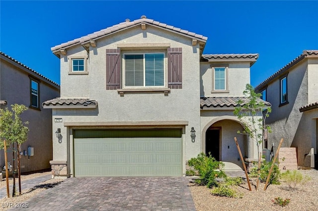 6747 Marjoram St, Las Vegas, NV 89166 - view of front of property featuring a tiled roof, an attached garage, stucco siding, and decorative driveway