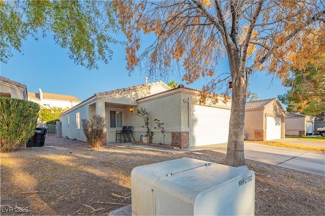 view of front of property featuring driveway, a tile roof, a garage, and stucco siding