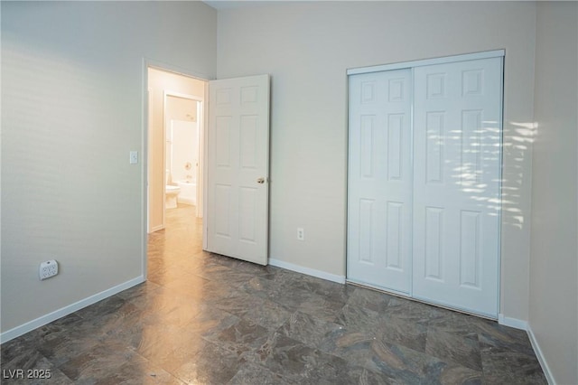 unfurnished bedroom featuring a closet and baseboards