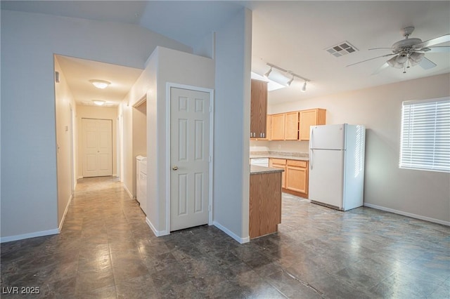 kitchen with baseboards, visible vents, ceiling fan, freestanding refrigerator, and light brown cabinets