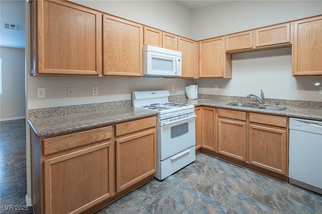 kitchen with white appliances, visible vents, a sink, and light brown cabinetry