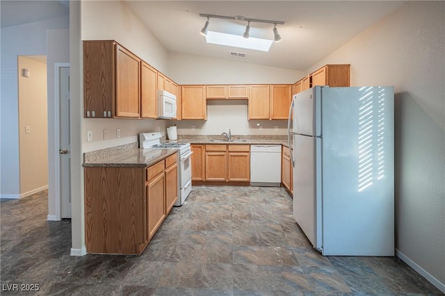 kitchen with lofted ceiling, white appliances, a sink, baseboards, and track lighting