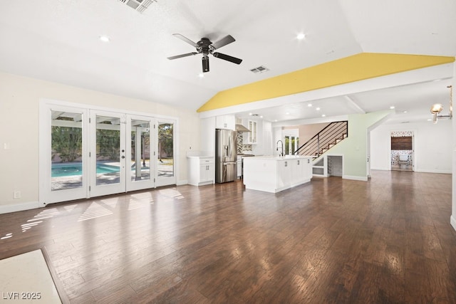 unfurnished living room with lofted ceiling, a sink, visible vents, and dark wood-style floors