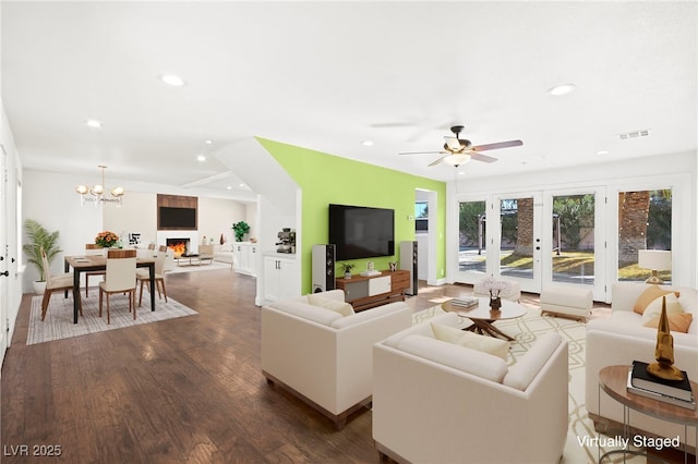 living area with visible vents, wood finished floors, ceiling fan with notable chandelier, french doors, and recessed lighting