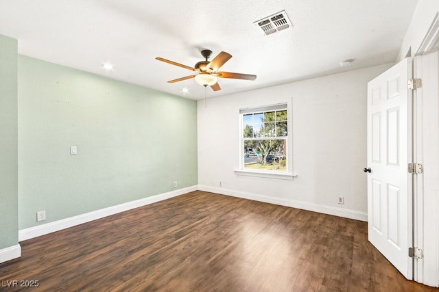 spare room featuring visible vents, ceiling fan, baseboards, and wood finished floors