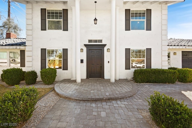 property entrance with visible vents and stucco siding