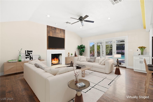 living room with lofted ceiling, a fireplace, and visible vents