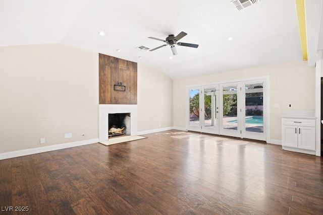 unfurnished living room with lofted ceiling, a fireplace, and visible vents