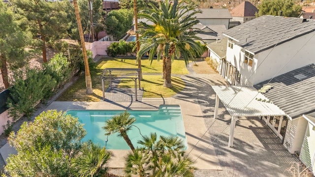 pool with a patio area and a lawn