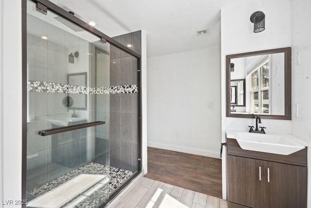 full bath with visible vents, a shower stall, vanity, and wood finished floors