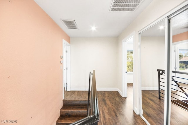 staircase with wood finished floors, visible vents, and a healthy amount of sunlight