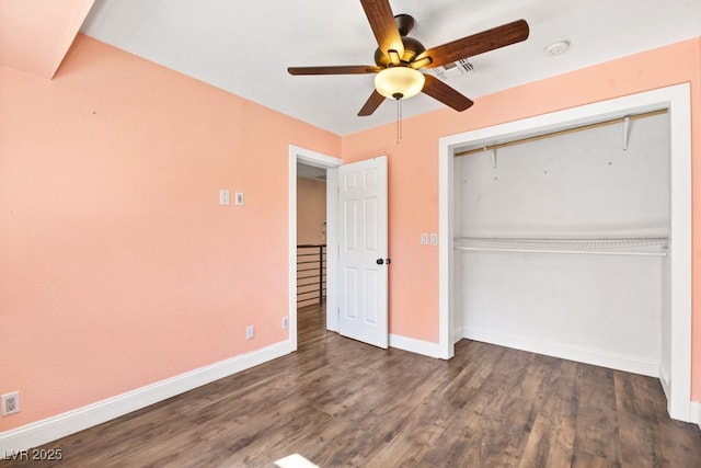 unfurnished bedroom with a closet, visible vents, a ceiling fan, wood finished floors, and baseboards