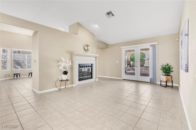 unfurnished living room featuring light tile patterned flooring, french doors, visible vents, and a tile fireplace