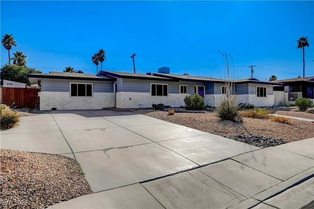 ranch-style house featuring brick siding and fence