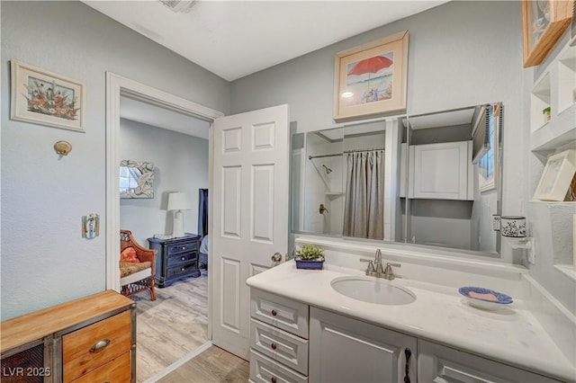 bathroom featuring curtained shower, vanity, and wood finished floors