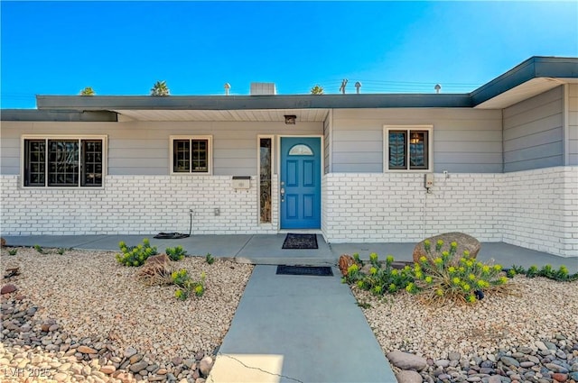 property entrance featuring brick siding