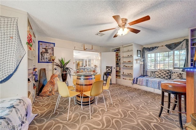 carpeted dining room with visible vents, a textured ceiling, and ceiling fan