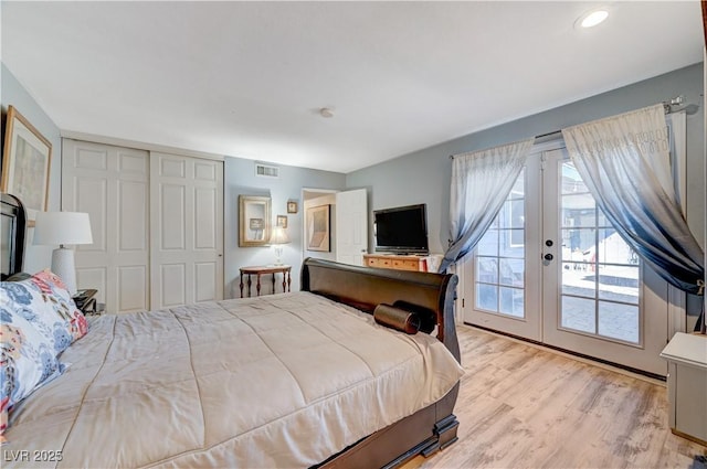 bedroom with visible vents, light wood-style flooring, french doors, a closet, and access to outside