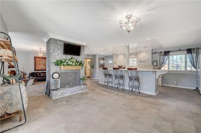 living room featuring recessed lighting, baseboards, a large fireplace, and an inviting chandelier