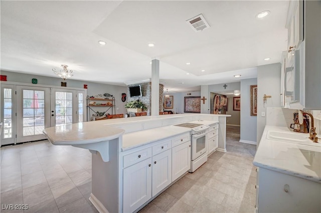 kitchen with visible vents, electric stove, a sink, recessed lighting, and french doors