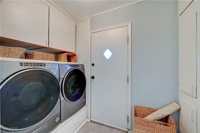 laundry area with crown molding, cabinet space, and washer and clothes dryer